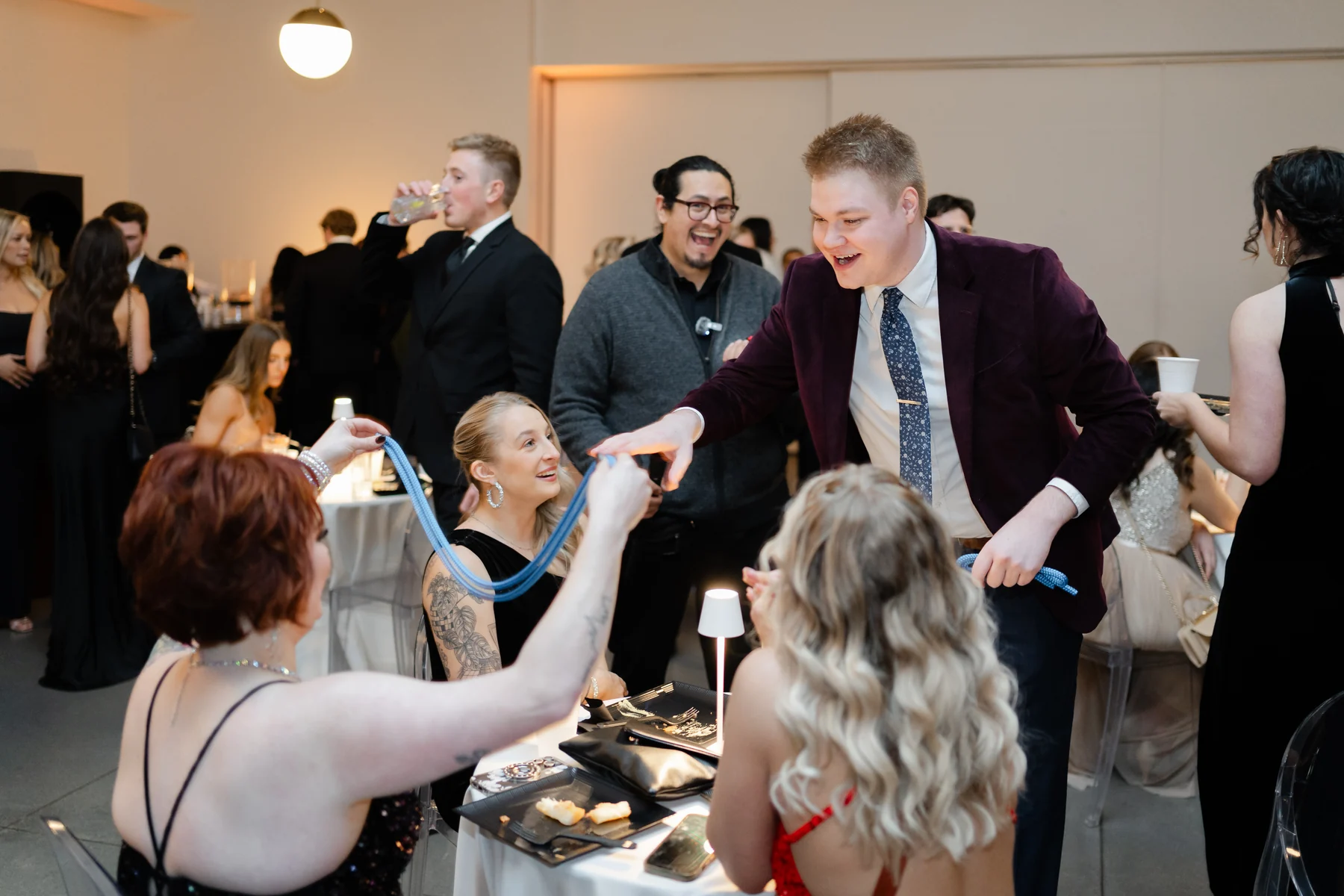Guests laughing as Chris Marvell performs rope magic around their reception table