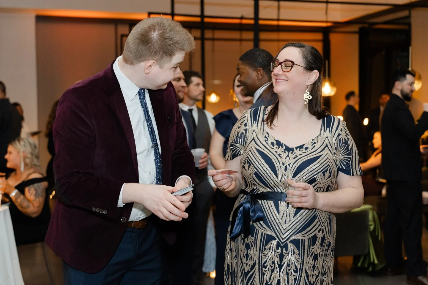 Chris sharing a close-up magic moment with a smiling event guest
